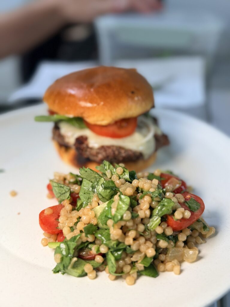 mediterranean couscous salad served with a burger
